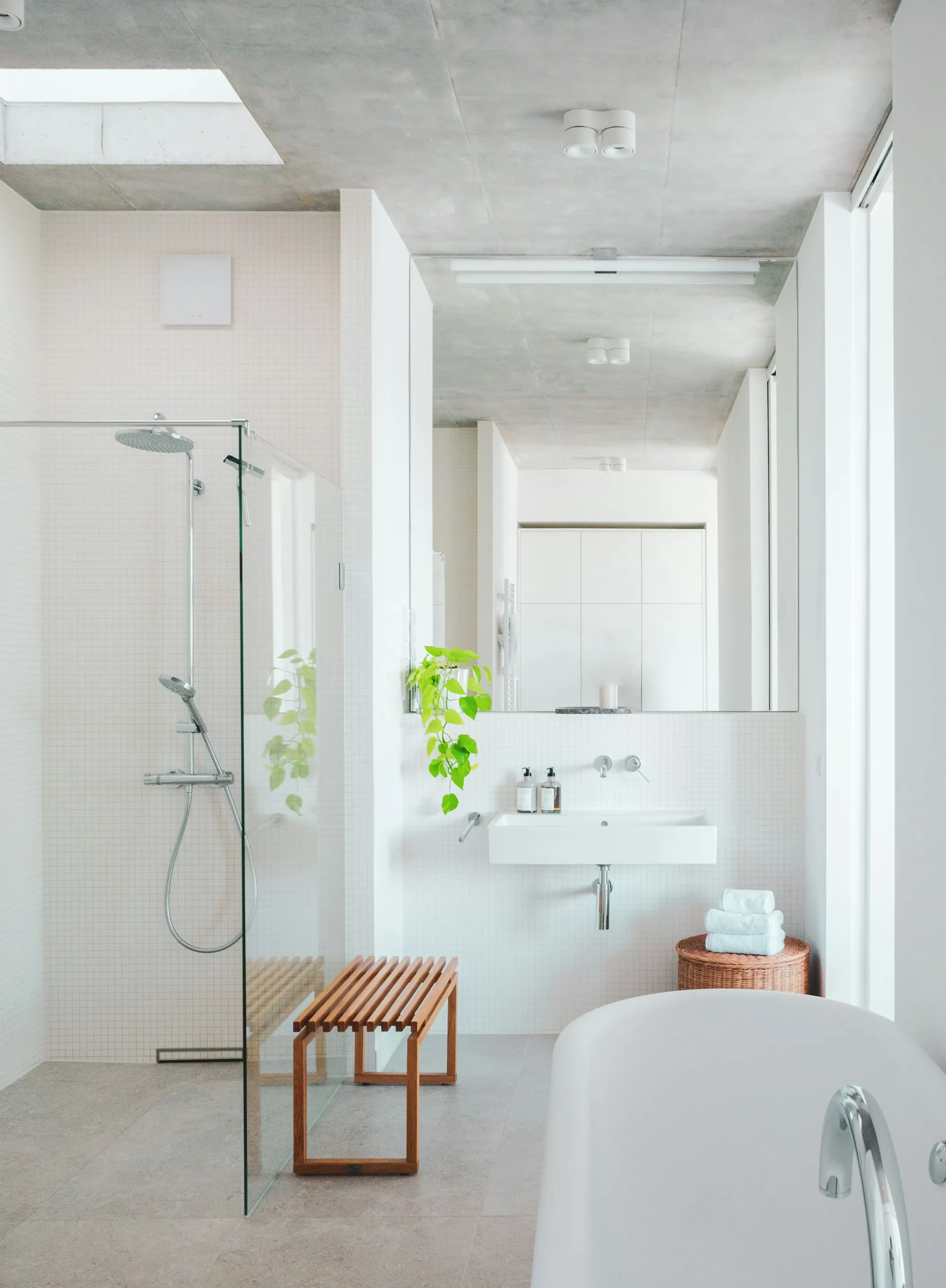 A clean, bright bathroom with a bath, basin and shower