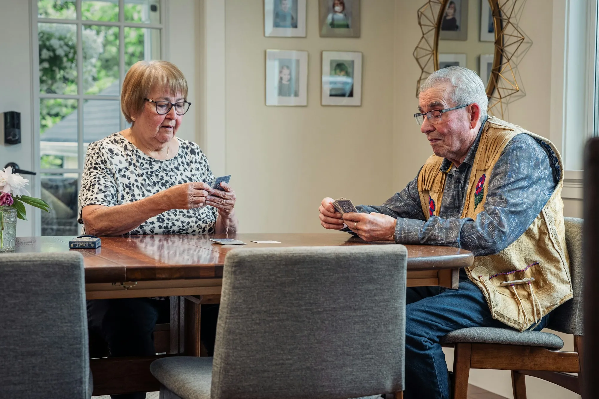 Two people playing cards at a dining table
