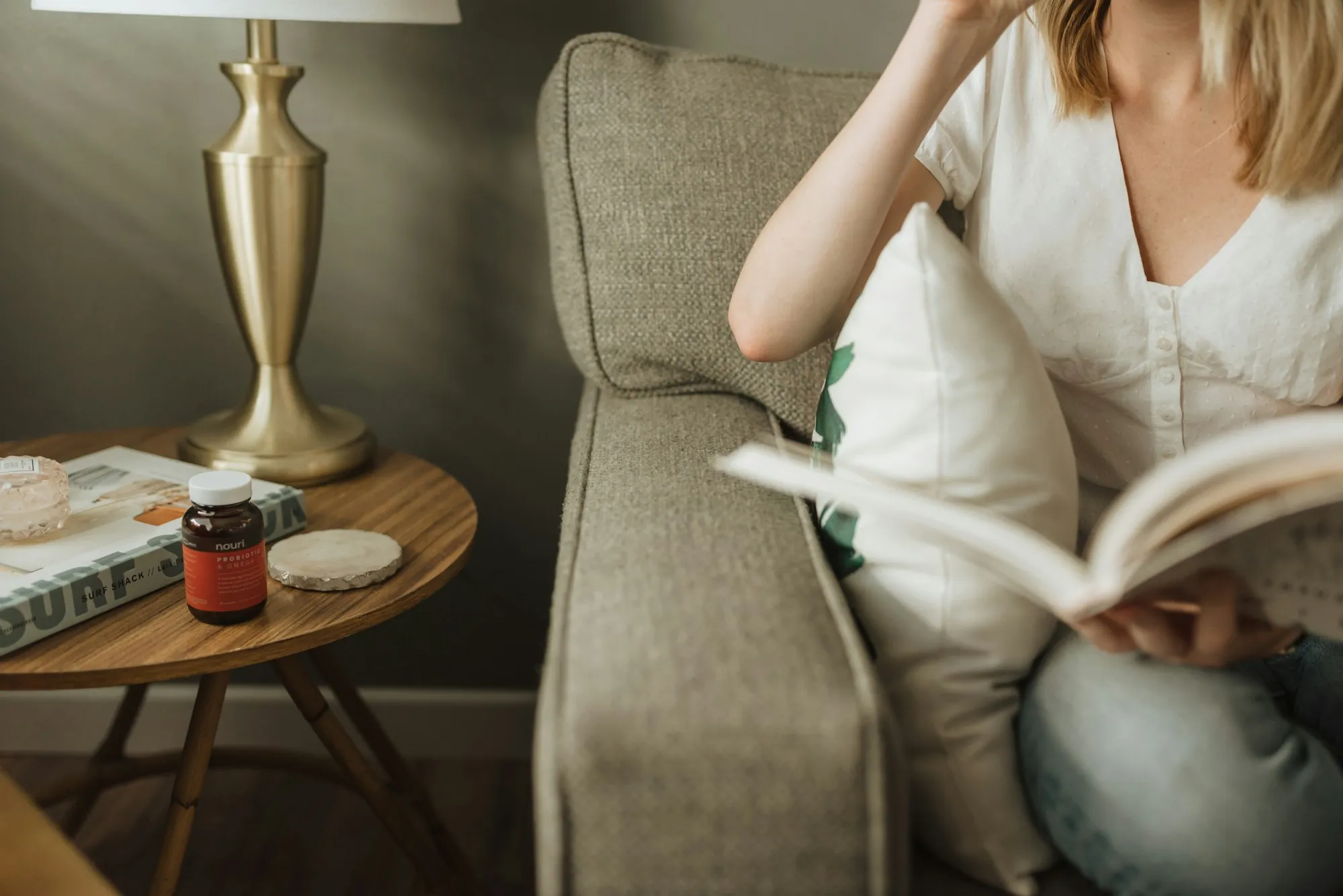 A woman sitting on a sofa with an open book