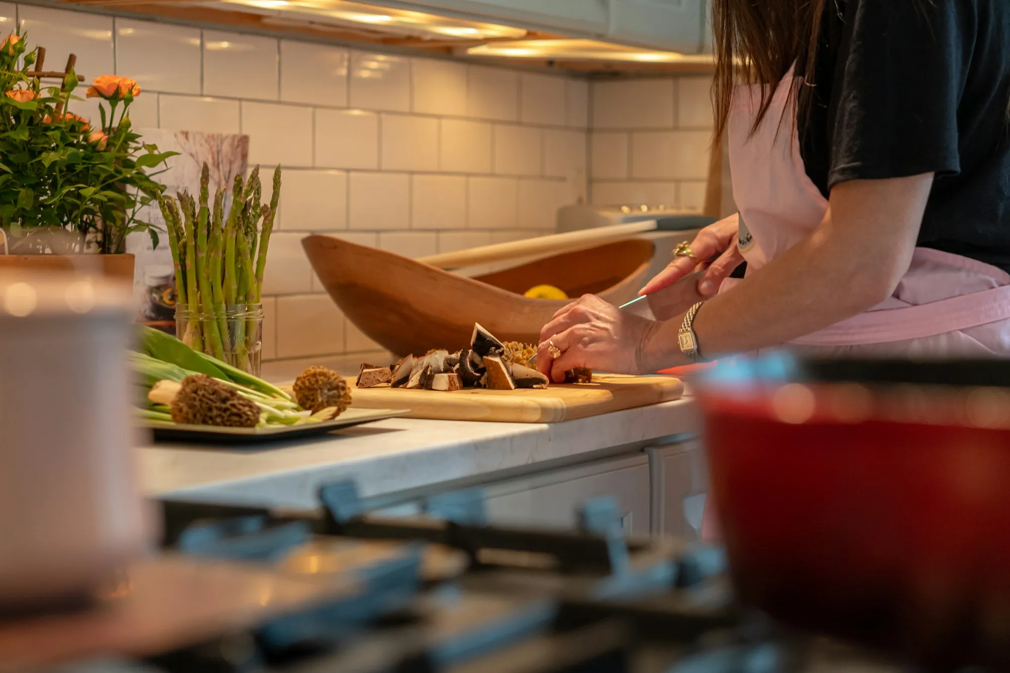 A woman chopping vegetables at a kitchen worktop